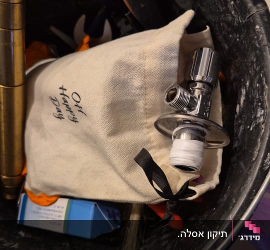 כלי עבודה וחלקי אינסטלציה בתוך דלי